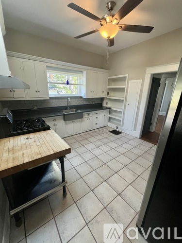 A kitchen with a wooden table and a ceiling fan.