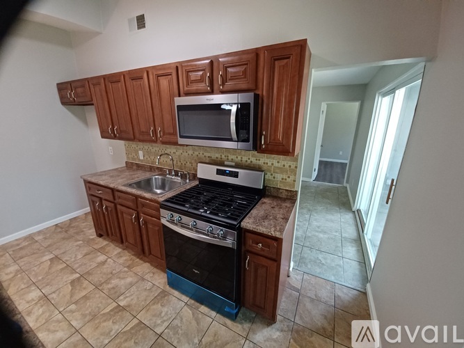 A kitchen with brown cabinets and a black stove top oven.