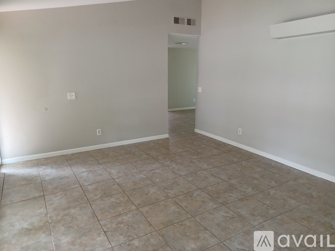A room with a tiled floor and a door in the background.