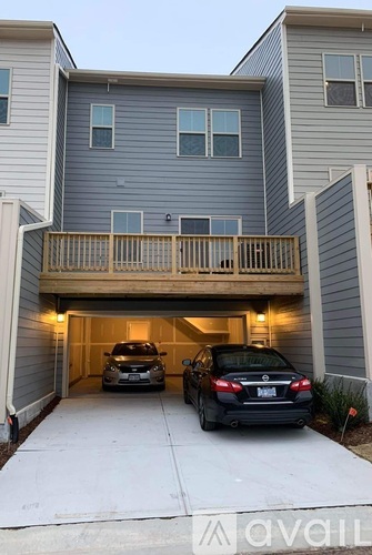 Two cars are parked in a garage attached to a house.