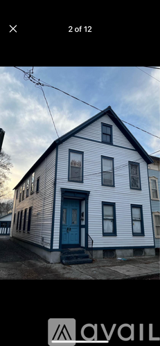 A white house with a blue door and windows.
