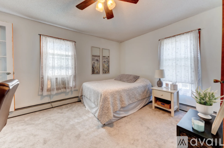 A bedroom with a bed, nightstand, and window.