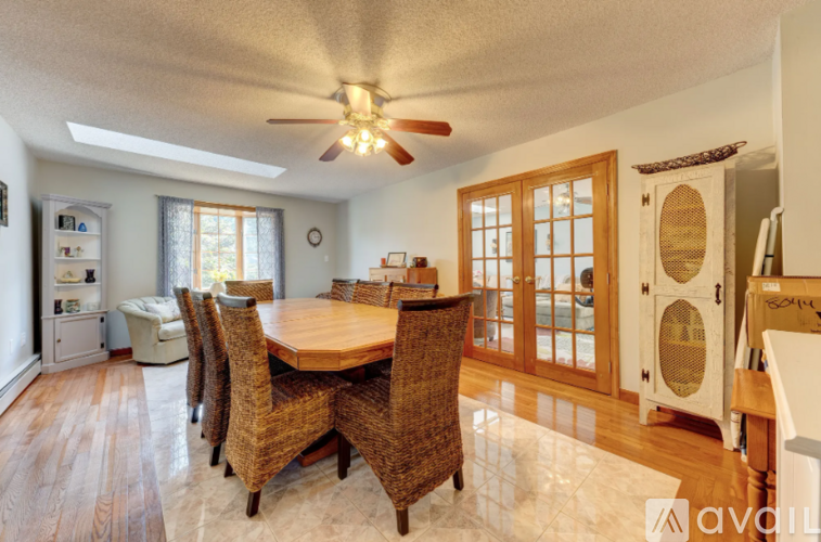 A dining room with a wooden table and chairs.