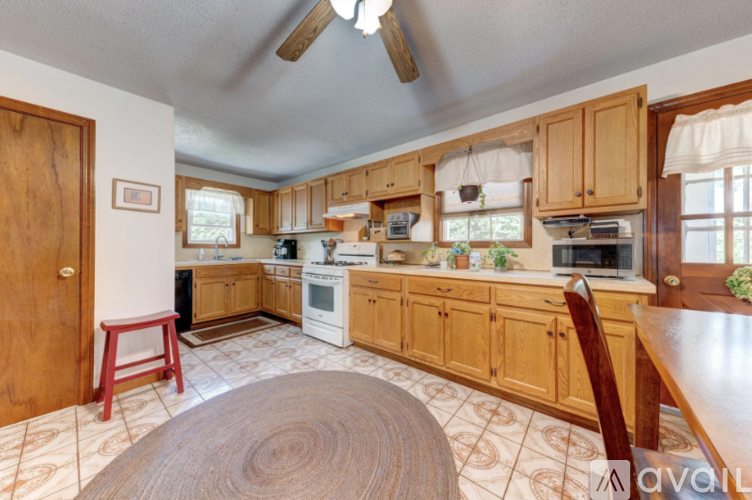 A kitchen with wooden cabinets and a white stove top oven.