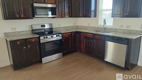A kitchen with dark wood cabinets and stainless steel appliances.