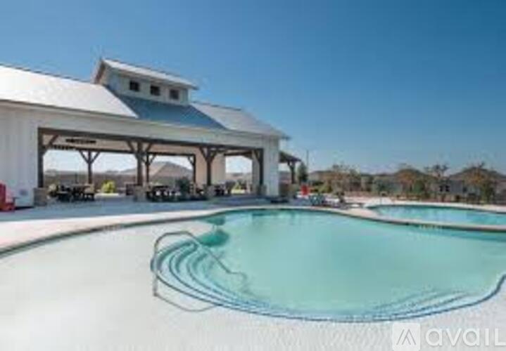 A large white building with a pool in front.
