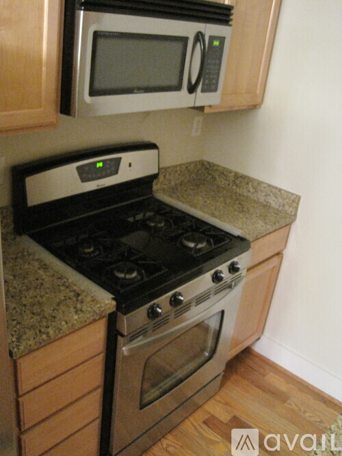 A kitchen with a stove and microwave above it.