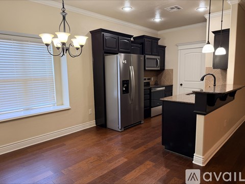A kitchen with a black counter and a refrigerator.