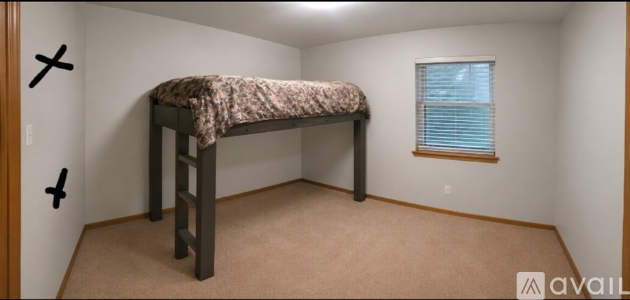 A bedroom with a bunk bed and a window.