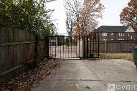 A black gate blocks the entrance to a driveway.
