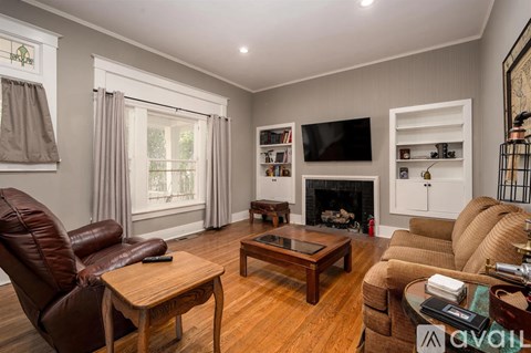 A living room with brown leather chairs and a wooden coffee table.