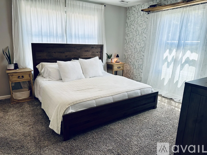 A bedroom with a large bed and a wooden headboard.