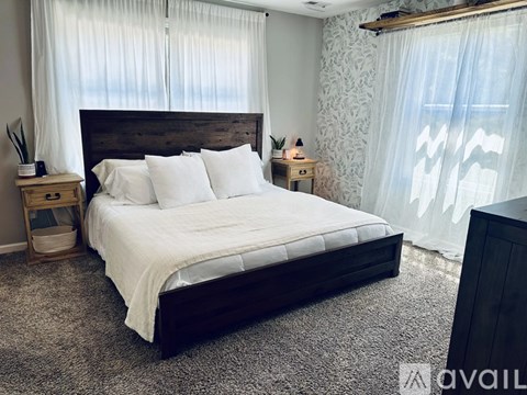 A bedroom with a large bed and a wooden headboard.