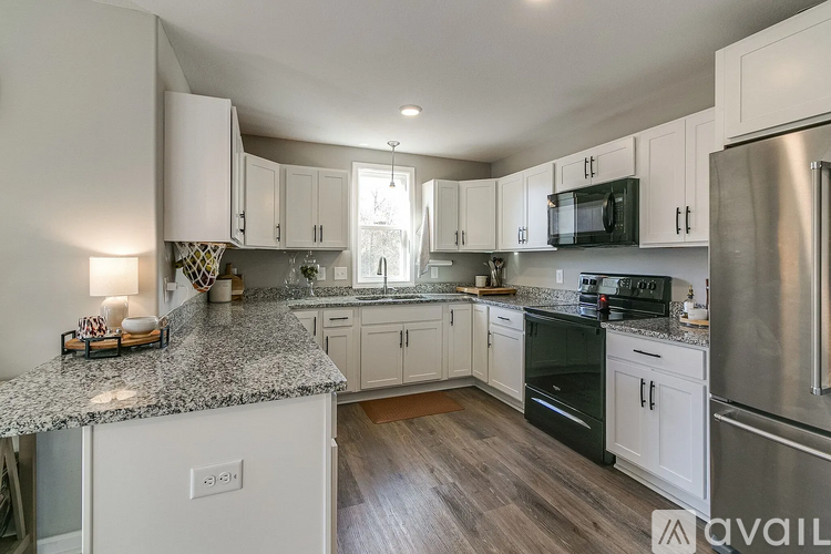 A kitchen with white cabinets and a granite countertop.