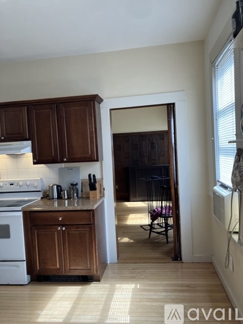 A kitchen with wooden cabinets and a white stove top oven.