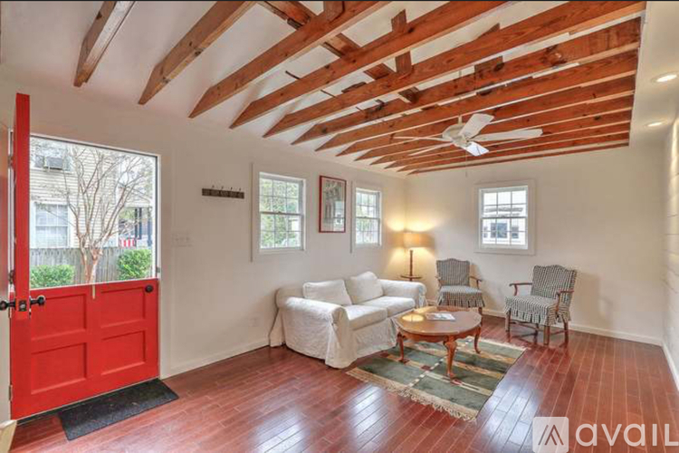 A room with a red door and wooden beams on the ceiling.