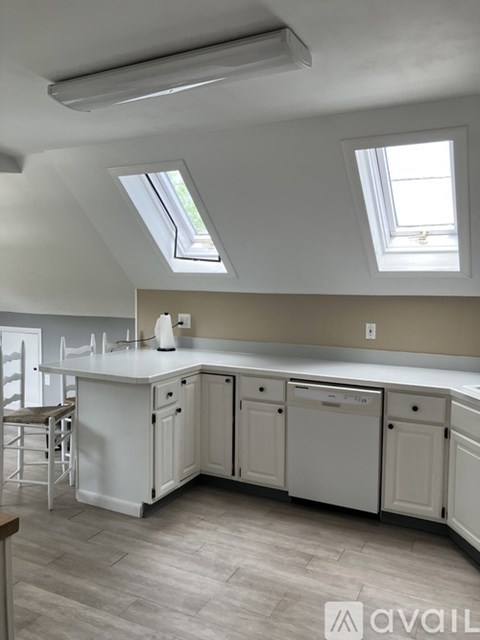 A kitchen with white cabinets and a large island.