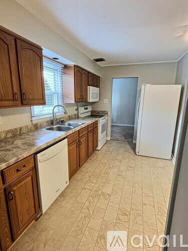 A kitchen with wooden cabinets and a white refrigerator.