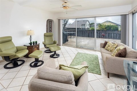 A living room with a green chair and a grey sofa.