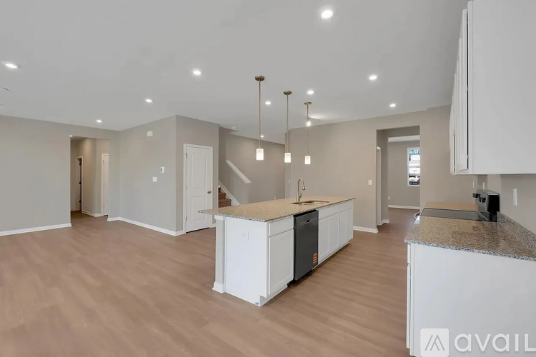 A spacious kitchen with white cabinets and a granite countertop.