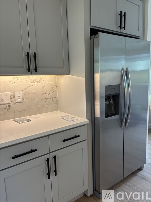 A kitchen with a refrigerator and cabinets.