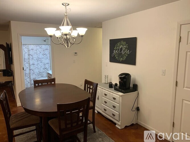 A dining room with a wooden table and chairs.