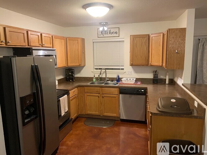 A kitchen with wooden cabinets and a black refrigerator.
