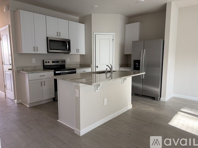 A kitchen with white cabinets and a marble countertop.