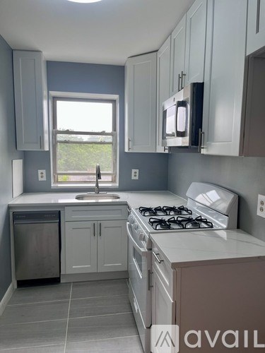 A kitchen with a stove, sink, and cabinets.