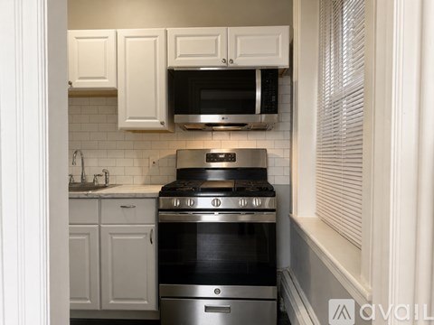 A kitchen with a stove top oven and microwave above it.