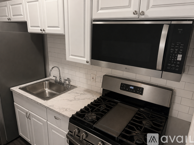 A kitchen with a stove, sink, and cabinets.
