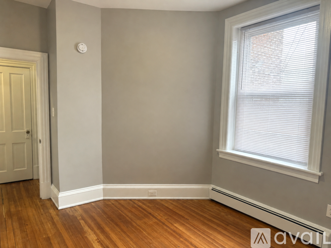 A room with a window and wooden floors.