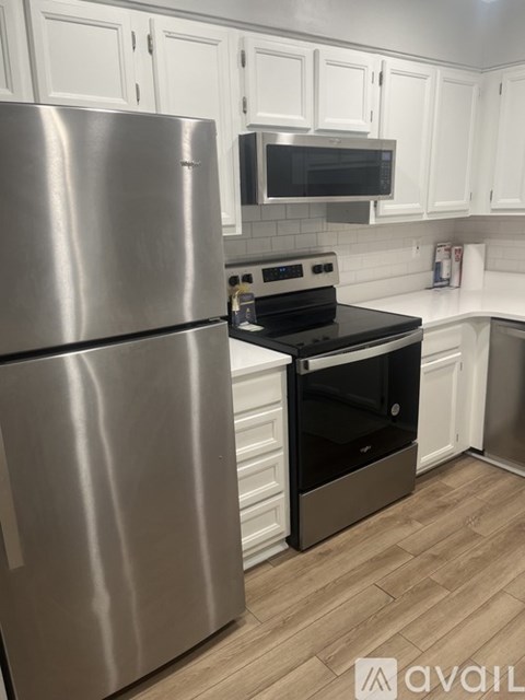 A kitchen with a stainless steel refrigerator and a black stove top oven.