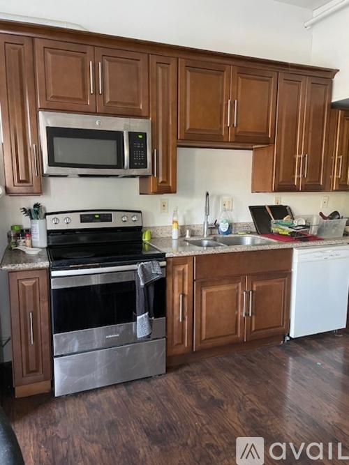 A kitchen with wooden cabinets and a stainless steel oven.