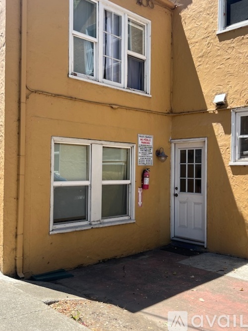 A yellow building with a white door and windows.