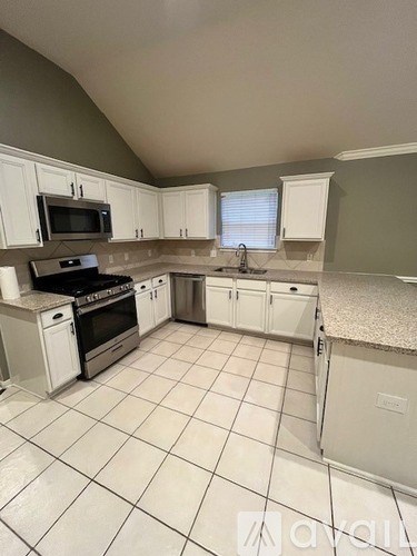 A kitchen with white appliances and cabinets.