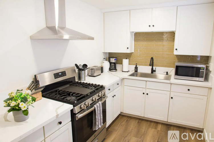 A kitchen with white cabinets and a black stove top oven.