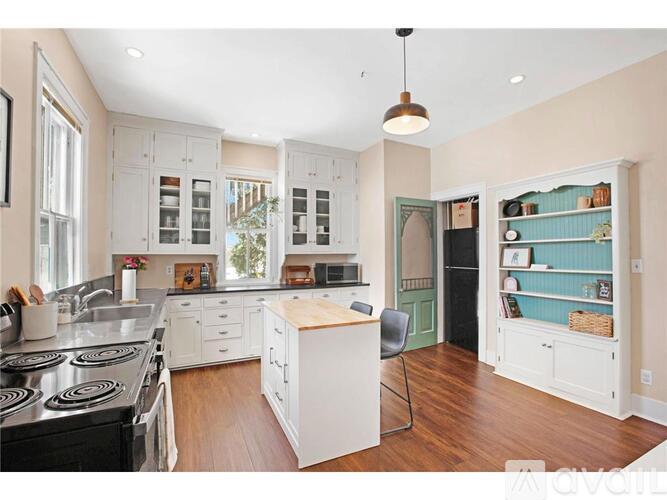 A kitchen with white cabinets and a black stove top oven.