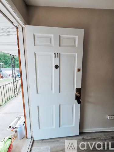 A white door with the number 11 on it is open.