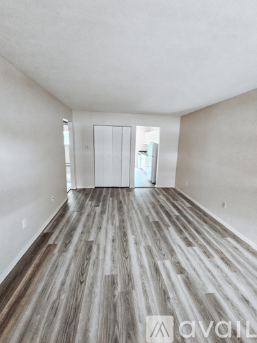 A room with wooden flooring and white walls.