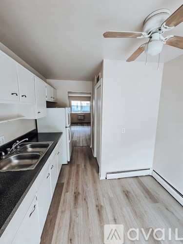A kitchen with white cabinets and a black countertop.