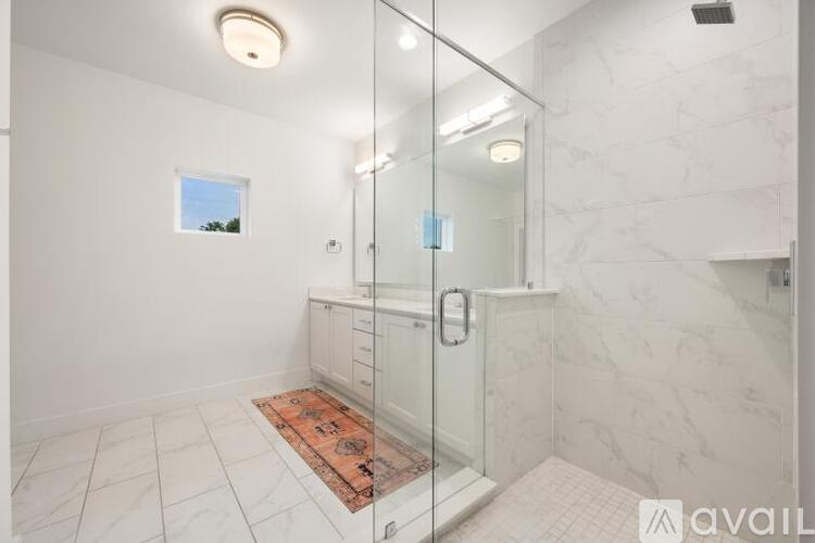A bathroom with a walk-in shower and a window.