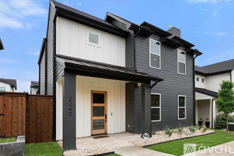 A modern house with a grey exterior and a wooden door.