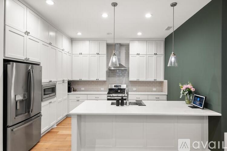 A modern kitchen with white cabinets and a central island.
