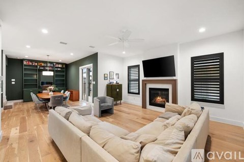 A living room with a beige couch and a fireplace.