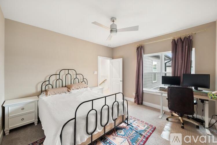 A bedroom with a bed, desk, and chair.