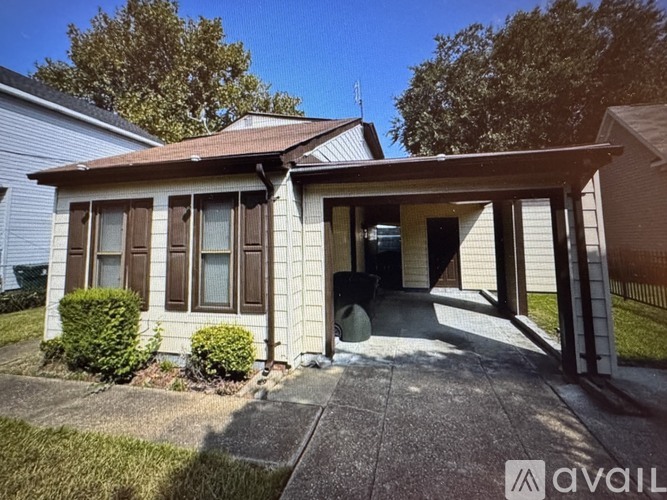 A house with a brown roof and a covered patio area.