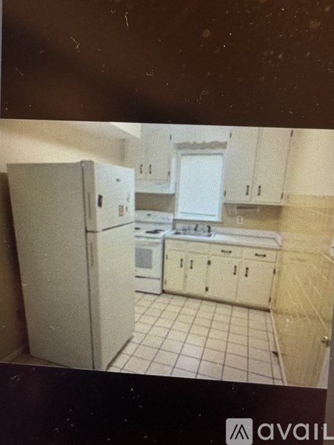 A kitchen with white appliances and cabinets.