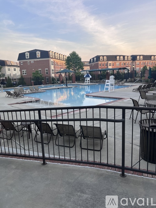 A pool area with chairs and a fence.