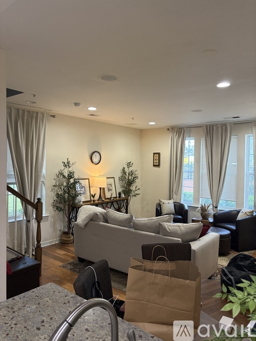 A living room with a couch, a chair, and a table with a plant on it.